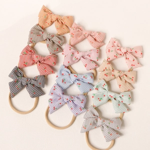 Détail de 11 bandeaux bébé à motifs vichy et cerises avec des élastiques en nylon