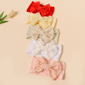 Dettaglio di cinque fasce per neonati con fiocchi in pizzo e morbido tessuto di nylon elastico