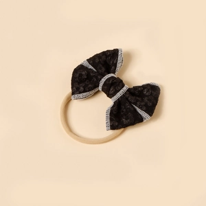 Detail of baby nylon headband with leopard print bow and gray stitching edges