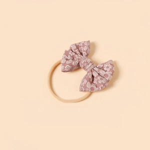 Detailed texture of dusty pink bow headband with elastic nylon for infants and babies