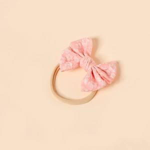 Close-up of baby headband featuring a pink jacquard bow with raised floral textures
