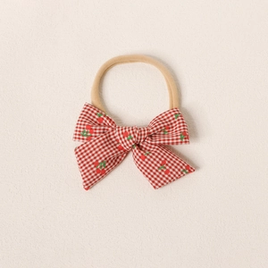 Détail du nœud vichy rouge pour bébé avec broderie de cerises sur bandeau en nylon