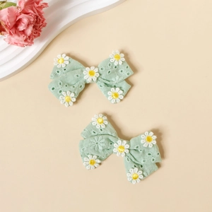 Détail de barrettes nœuds en coton vert menthe avec broderie marguerite pour filles