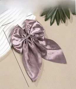 Détail d'un nœud en satin avec accents de strass et spécifications de taille