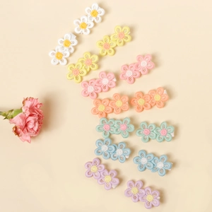 Detail view of multi-color floral embroidery hair clips in sweet daisy patterns