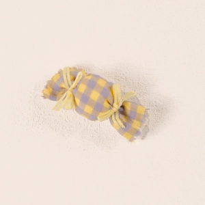 Close-up of yellow and purple plaid candy-shaped fabric hair clip for baby girls