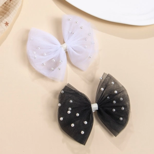 Détail des barrettes nœuds en maille avec perles et revêtement en tissu doux pour enfant