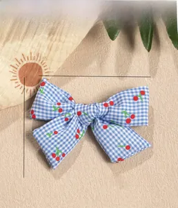 Blue plaid fabric bow with cherry print showing size dimensions 9cm by 7cm