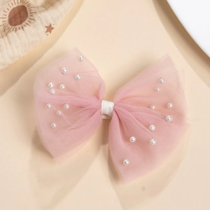 Détail de la barrette en tulle rose avec perles et pince enveloppée de tissu doux