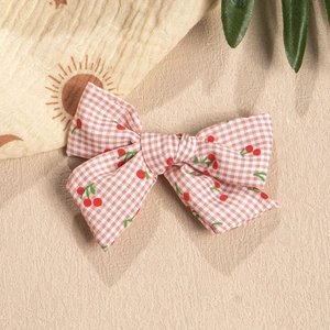 Detail of pink plaid fabric hair bow with cherry pattern for DIY children clips
