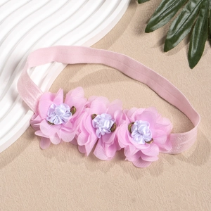 Detailaufnahme von rosa Netzstoffblumen mit Satinmitte auf einem Baby-Haarband