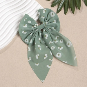 Detaillierte Nahaufnahme der salbeigrünen Chiffon Schleife mit weißem Gänseblümchen