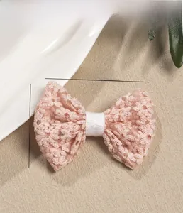 Detailed view of pink lace bow hair clip with size dimensions 8cm by 6cm and mesh embroidery