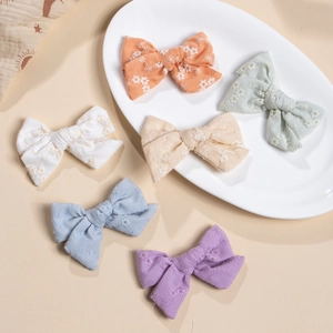 Close-up of a 6-piece set of handmade floral embroidery cotton bow hair clips in pastel colors