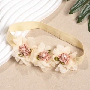 Details von Baby-Stirnband mit handgefertigten Stoffblumen und weichen grünen Blättern