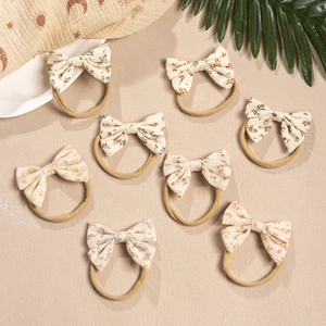 Detailed macro view of 8-pack floral bow headbands with elastic nylon bands for babies