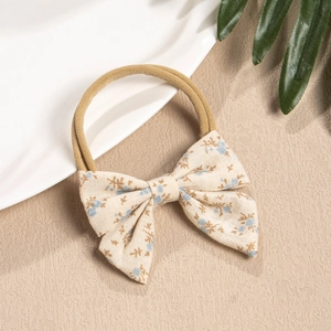 Close-up of floral fabric bow headband with soft nylon elastic and beige floral pattern