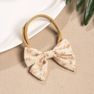Detail of floral linen bow on stretchy nylon baby headband for children's hair styling