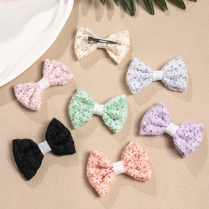 Detail of multi-color lace bow hair clips set with delicate floral embroidery and metal clips