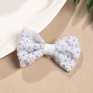 Close-up of white crochet flower hair clip with delicate lace mesh and metal clamp detail