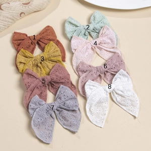 Huit barrettes à nœuds en coton avec broderies fleurs évidées dans des tons variés