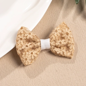 Detailed view of handmade lace bow hair clip with intricate floral embroidery patterns