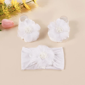 Close-up of white elastic headband and foot flowers set with layered mesh petals
