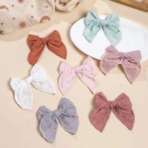 Détail de nœuds à cheveux en coton coloré avec broderie évidée et bordures ondulées