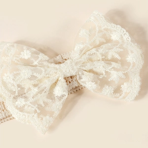Détail d'un nœud en dentelle brodée et bandeau au crochet pour bébés et nourrissons