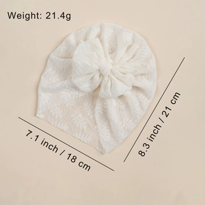 Infant beige mesh turban hat with large bow detail and breathable lace pattern