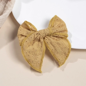 Détail du nœud papillon brodé jaune moutarde avec bordures en dentelle au crochet
