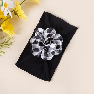 Detailed texture of black elastic nylon baby headband with a plaid fabric flower decoration