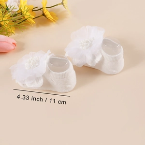 Detailed view of white knitted baby socks featuring mesh 3D flowers with 11cm size guide