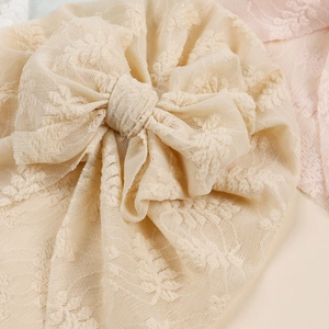 Soft beige lace baby turban with flower pattern and a large bow for infants