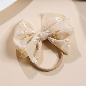 Detail der Textur des Baby-Nylon-Stirnbandes mit Netzschleife und Gänseblümchen