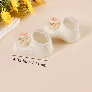 Detail view of baby socks in cream with peach lace flowers and 11cm size annotation