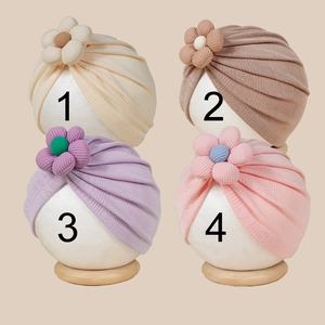 Vue détaillée de quatre turbans pour bébé en tricot côtelé avec fleurs 3D pastel