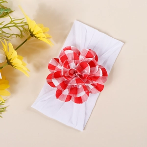Detail of red gingham pattern bow on elastic white nylon baby headband for infants
