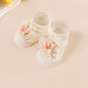 Detailed close-up of soft cotton baby socks featuring delicate pink floral embellishments