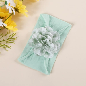 Detail of baby nylon headband with a light green and white checkered fabric flower decor