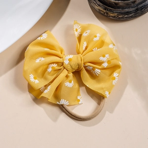Detail von gelber Baby-Haarschleife mit Gänseblümchen-Muster und Nylonband