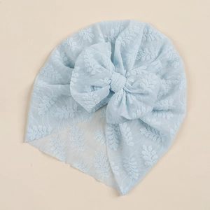 Detail of baby light blue lace turban hat with floral embroidery and a large bow decoration