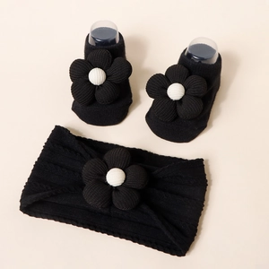 Detail view of black knit baby headband and socks set with 3D floral accents