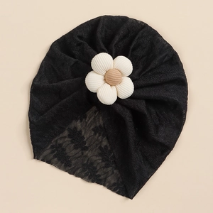 Detailed macro of black lace baby turban with a 3D textured cream fabric flower accent