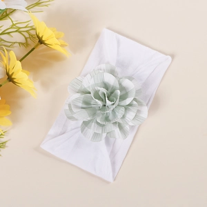Close-up of baby headband with a soft green plaid fabric flower on a white elastic band