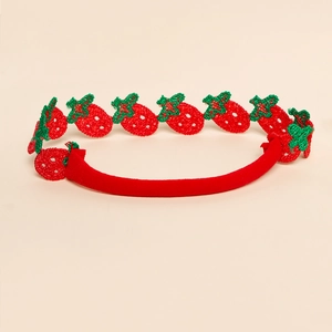 Gros plan du bandeau pour bébé avec motifs de fraises brodées rouges sur tissu doux