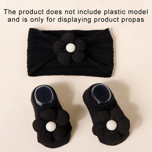 Detail of baby headband and socks set with 3D floral accents and ribbed knit texture