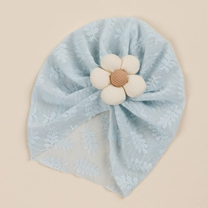 Detail of baby lace turban with large plush flower showing delicate mesh texture
