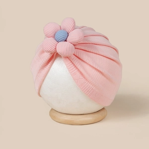 Détail du bonnet turban rose pour bébé avec fleur 3D et texture élastique douce