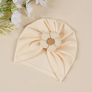 Détail du bonnet turban pour bébé avec grande fleur 3D et texture tricotée douce